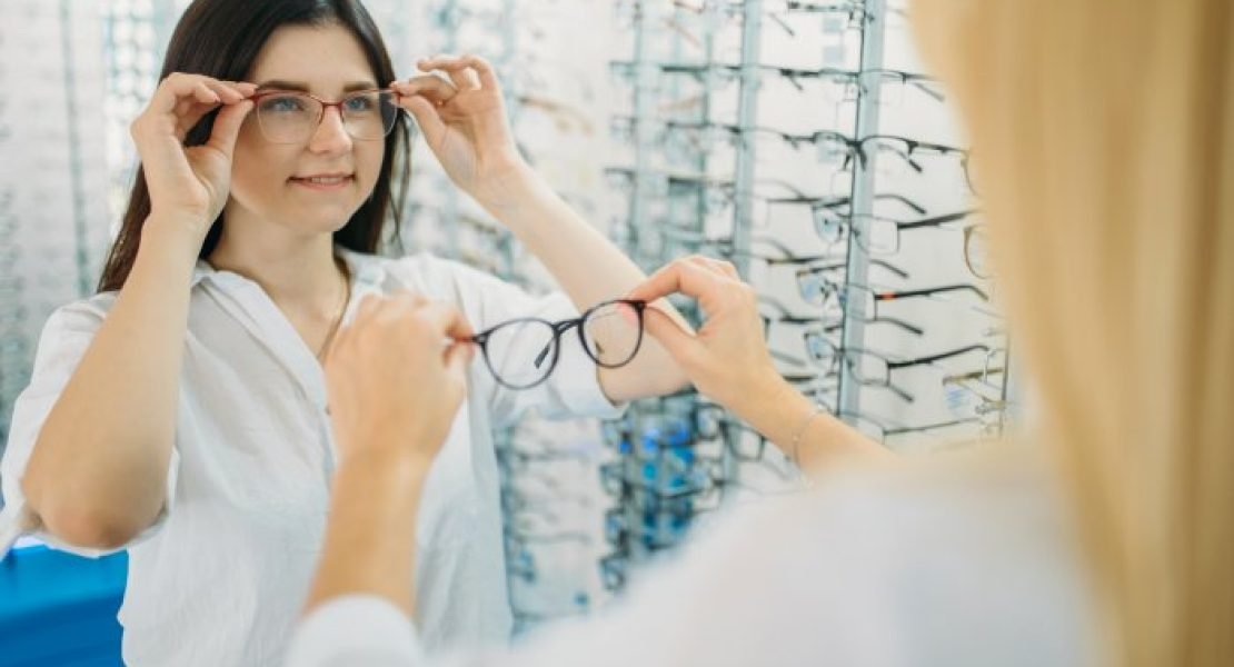 Customer trying on spectacle frames at an optical store display